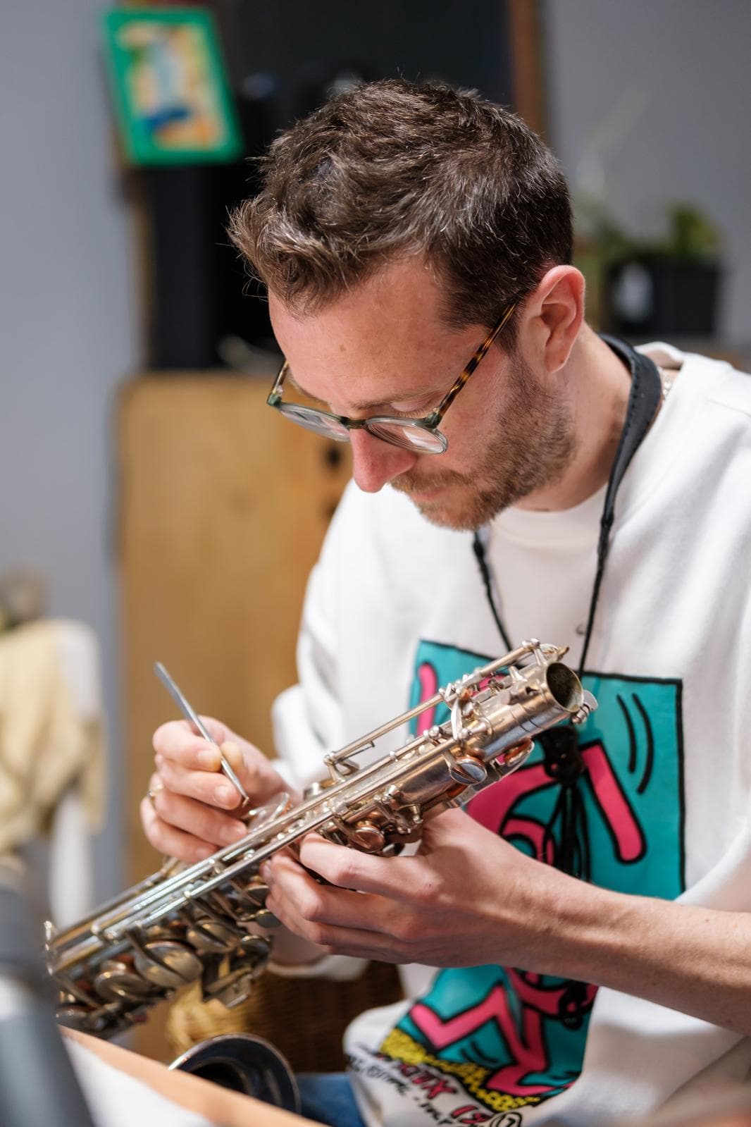 Joe sat with saxophone and tool in hand