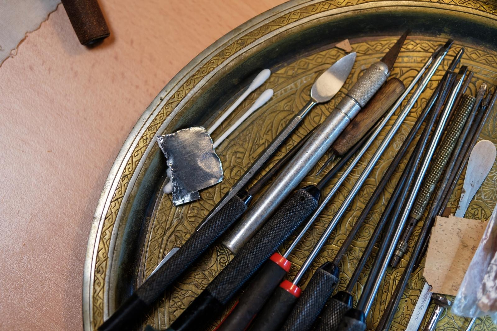 A shot of a dish filled with more tools, including screwdrivers and files